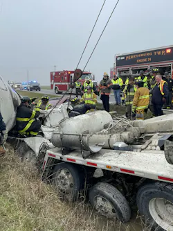 A rescuer (far left) uses hand signals to indicate what he needs the wrecker operator to do. A rescuer (far left) uses hand signals to indicate what he needs the wrecker operator to do.