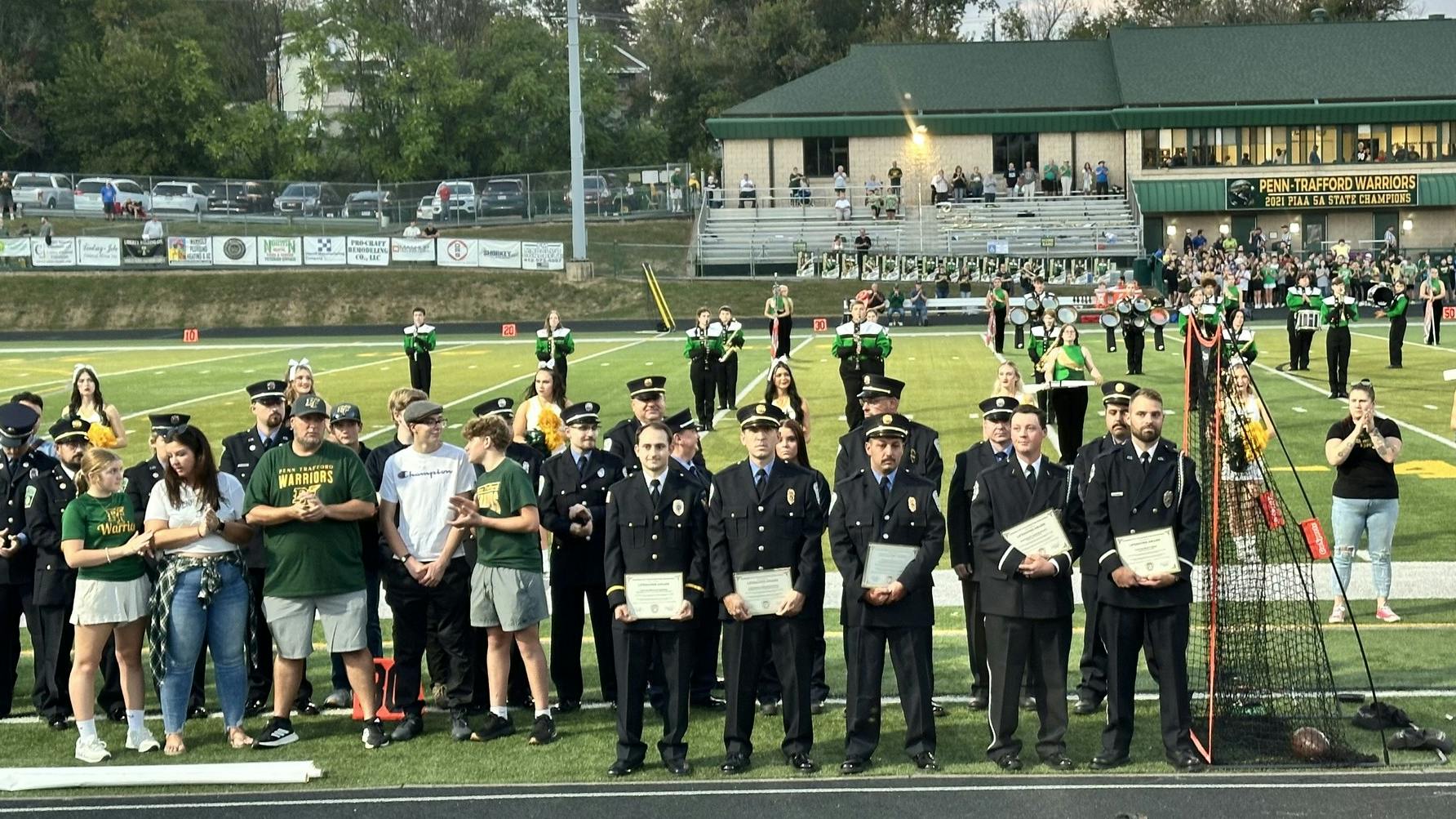 The five firefighers involved in the rescue were recognized during a ceremony at Penn-Trafford's Warrior Stadium before the high school football game.