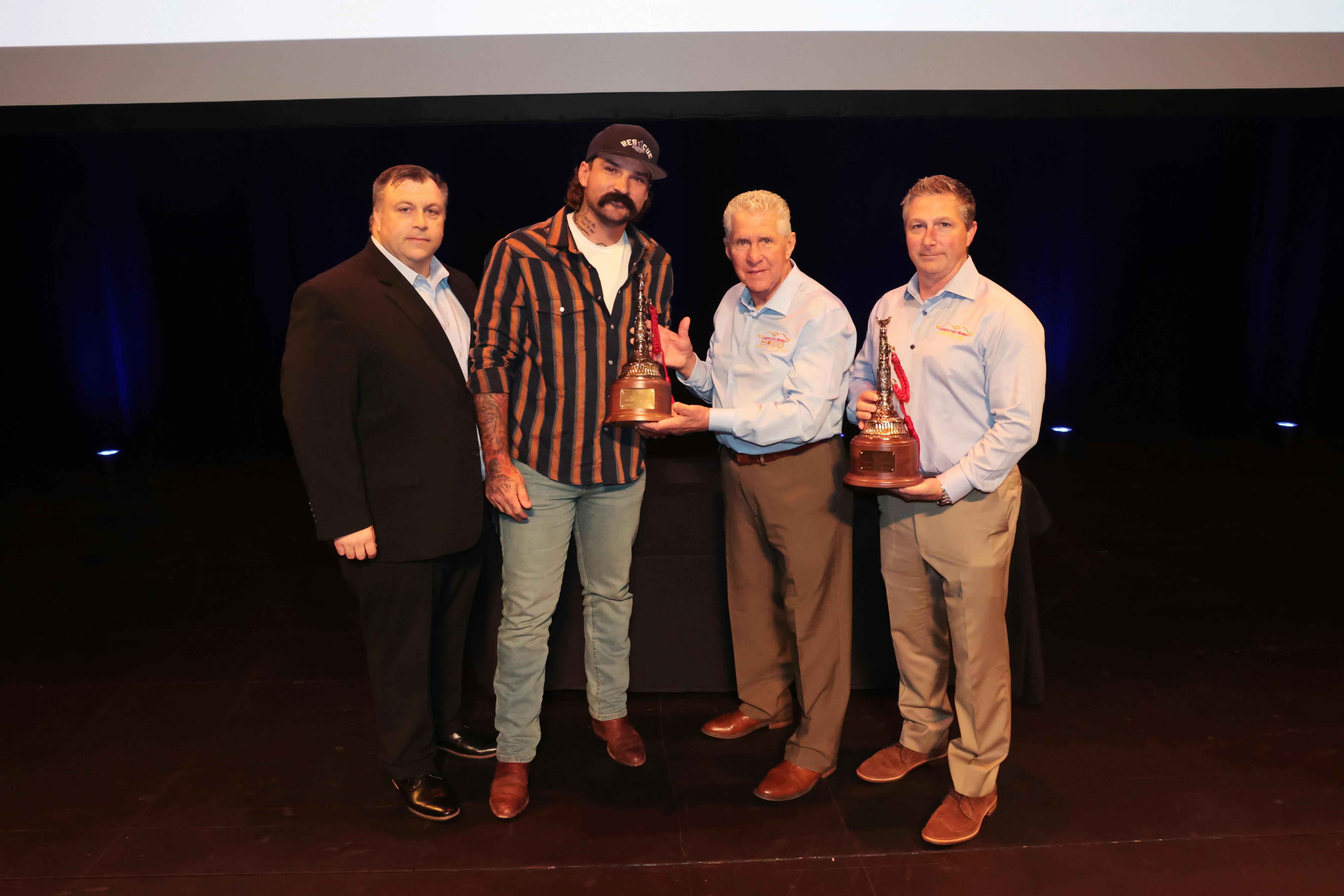 Michael O. McNamee Award of Valor honoree Jake Ryks (second from left) is joined by Firehouse's Peter Matthews (left) and Robert Daus Sr. (second from right) and Robert Daus Jr. (right) from Liberty Artworks, who presented their hand crafted award to Ryks.