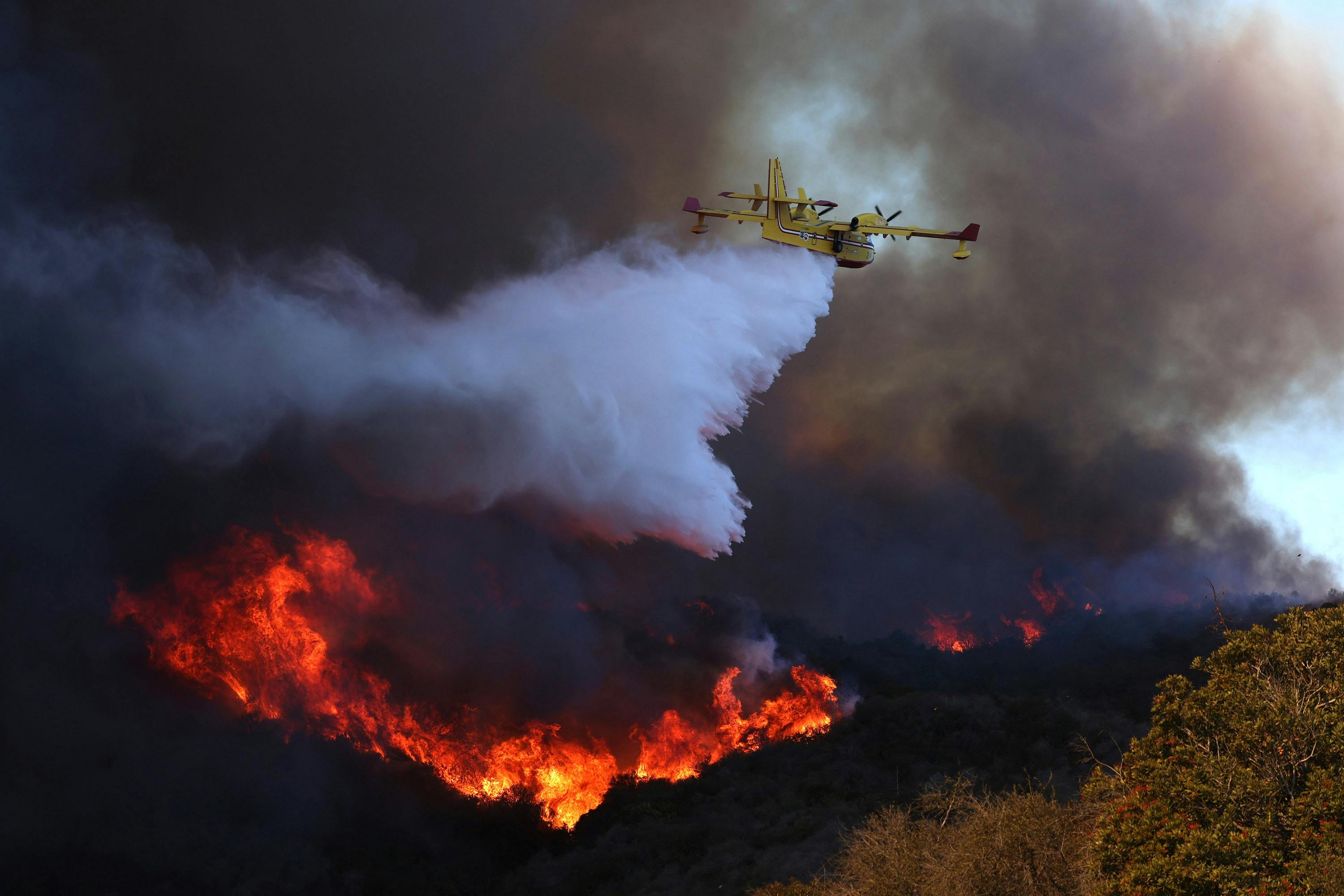 A firefighting plane drops water on the Palisades fire on Jan. 7, 2025.