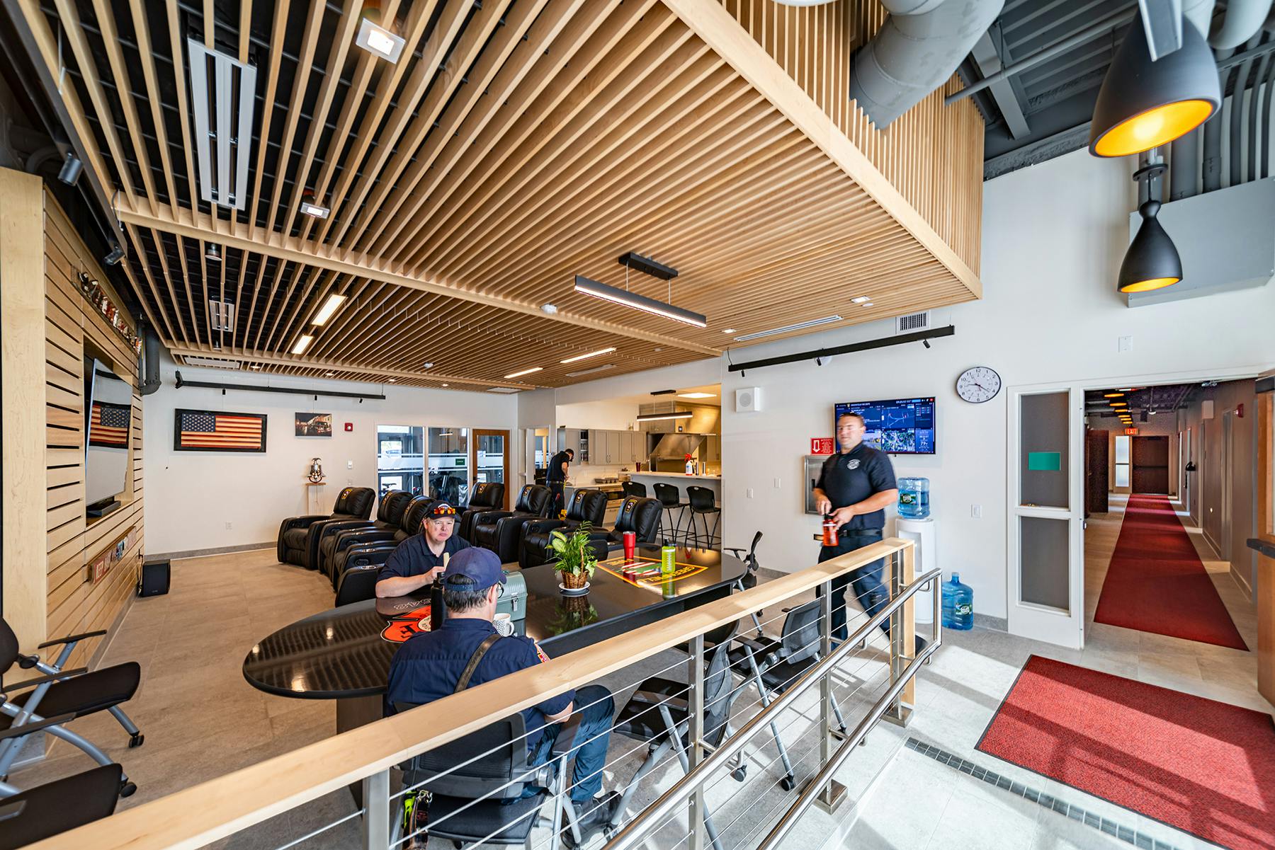 The new fire headquarters in Greenfield, MA, features an open-concept layout between the dayroom and kitchen, enhanced by warm wood tones, acoustic ceilings and wall panels.