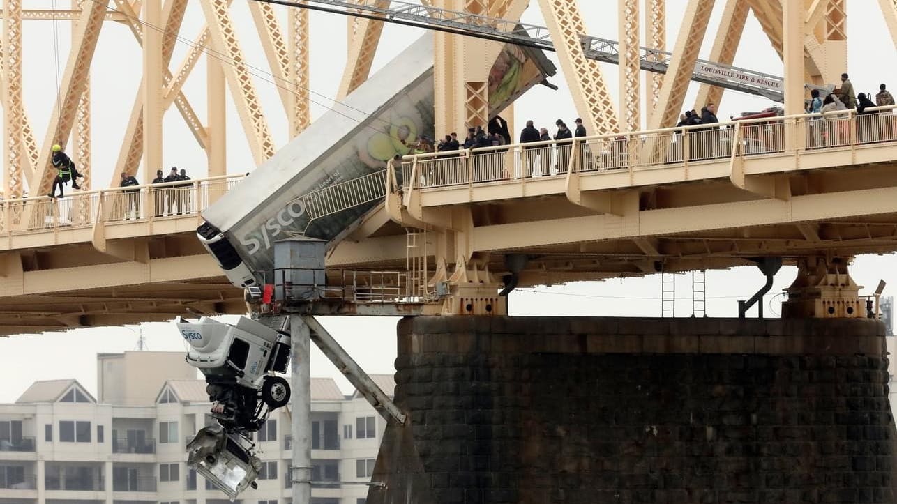The scene at the first of two accidents where tractor-trailer cabs were left hanging over the Ohio River from a bridge.