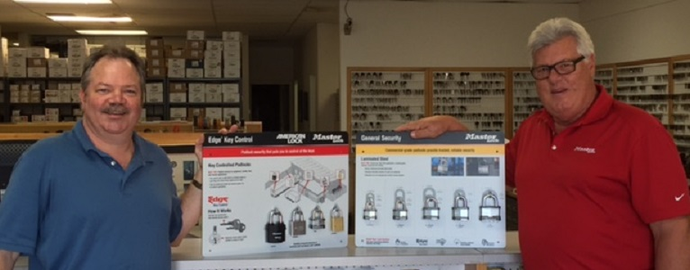 Bob Morrissette (left) and Master Lock field representative Ed Skaaland, stand next to American Lock and Master Lock customer merchandise display boards.