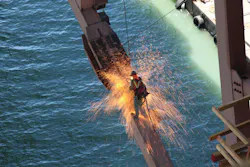 California Department of Transportation Engineer Martin Chandrawinata's photograph of an iron worker using a cutting torch while suspended from the San Francisco-Oakland Bay Bridge. California Department of Transportation Engineer Martin Chandrawinata's photograph of an iron worker using a cutting torch while suspended from the San Francisco-Oakland Bay Bridge.