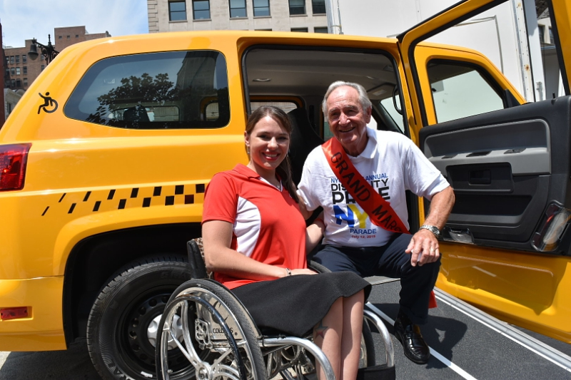 Mobility Ventures, spokesperson Kristina Rhodes, and Former Senator Tom Harkin, architect of the American's with Disability Act (ADA), pose in the entrance of a new MV-1 vehicle. The new 2016 MV-1 was unveiled at the New York City Disability Pride Parade where Mobility Ventures was the lead sponsor.
