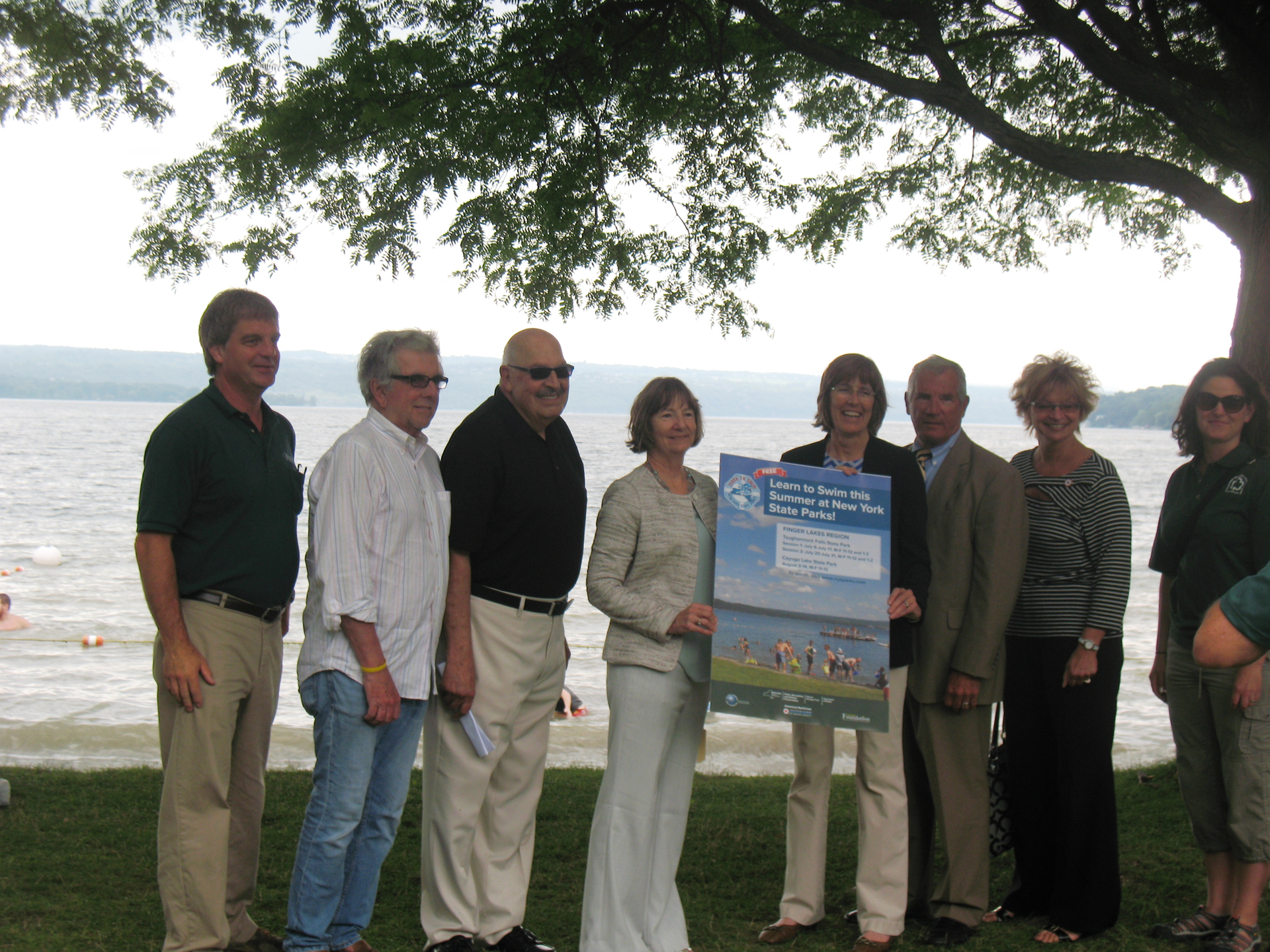 TCAT Acting General Manager Alice Eccleston, fourth from left, holds a Learn to Swim poster with Commissioner Rose Harvey, New York State Office of Parks, Recreation and Historic Preservation.