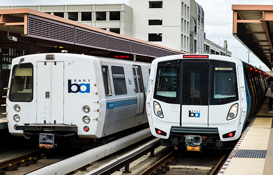Train from current fleet at left and a new train car, right, still in testing mode.