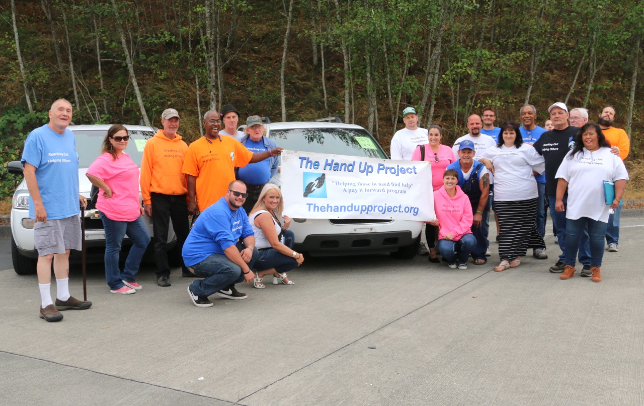 Staff and volunteers for The Hand Up Project celebrate their new van.