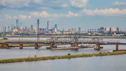 An Amtrak train crosses the Portal North Bridge with New York City in the background. An Amtrak train crosses the Portal North Bridge with New York City in the background.