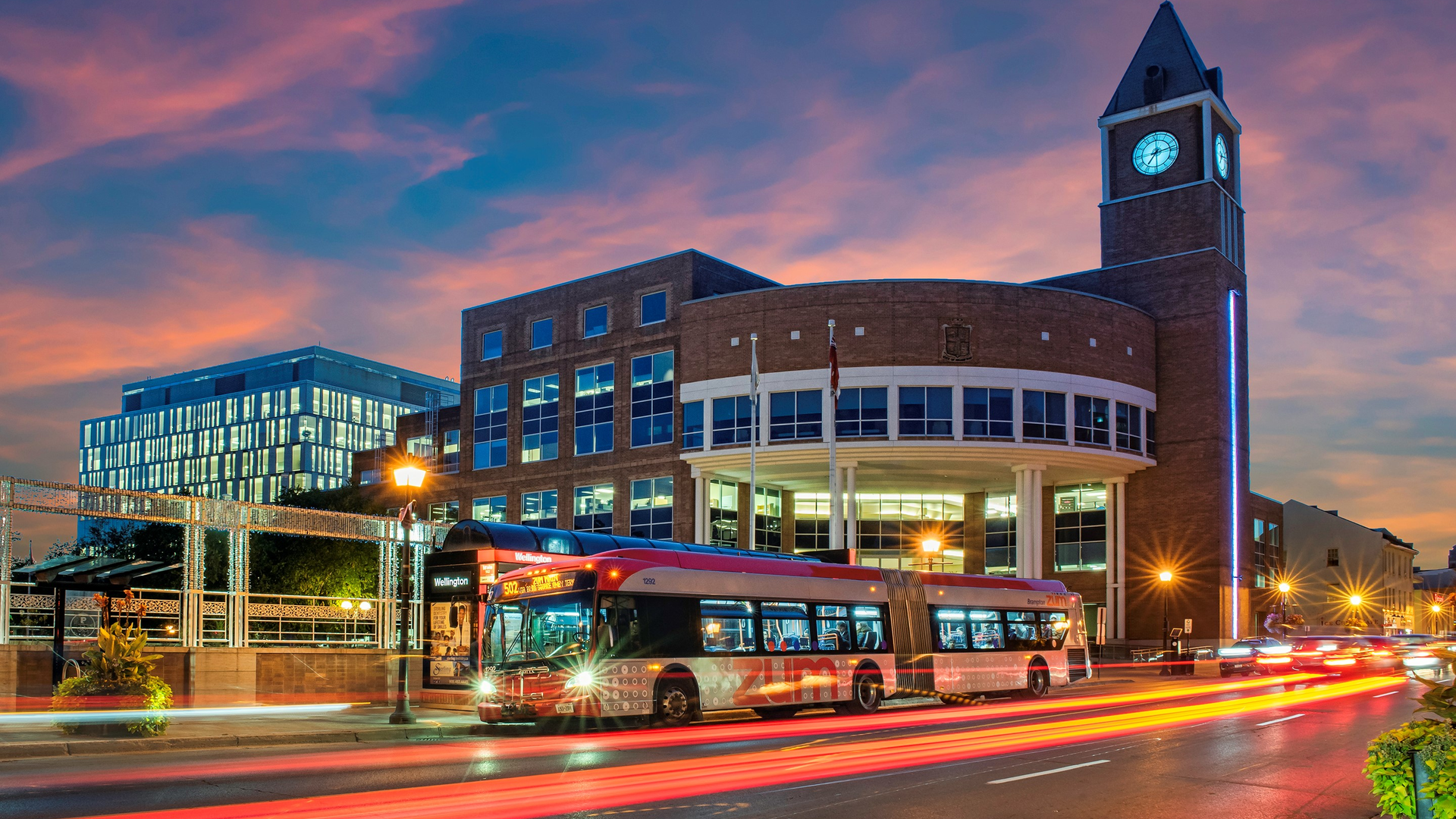A Zum bus travels in front of Brampton's City Hall.