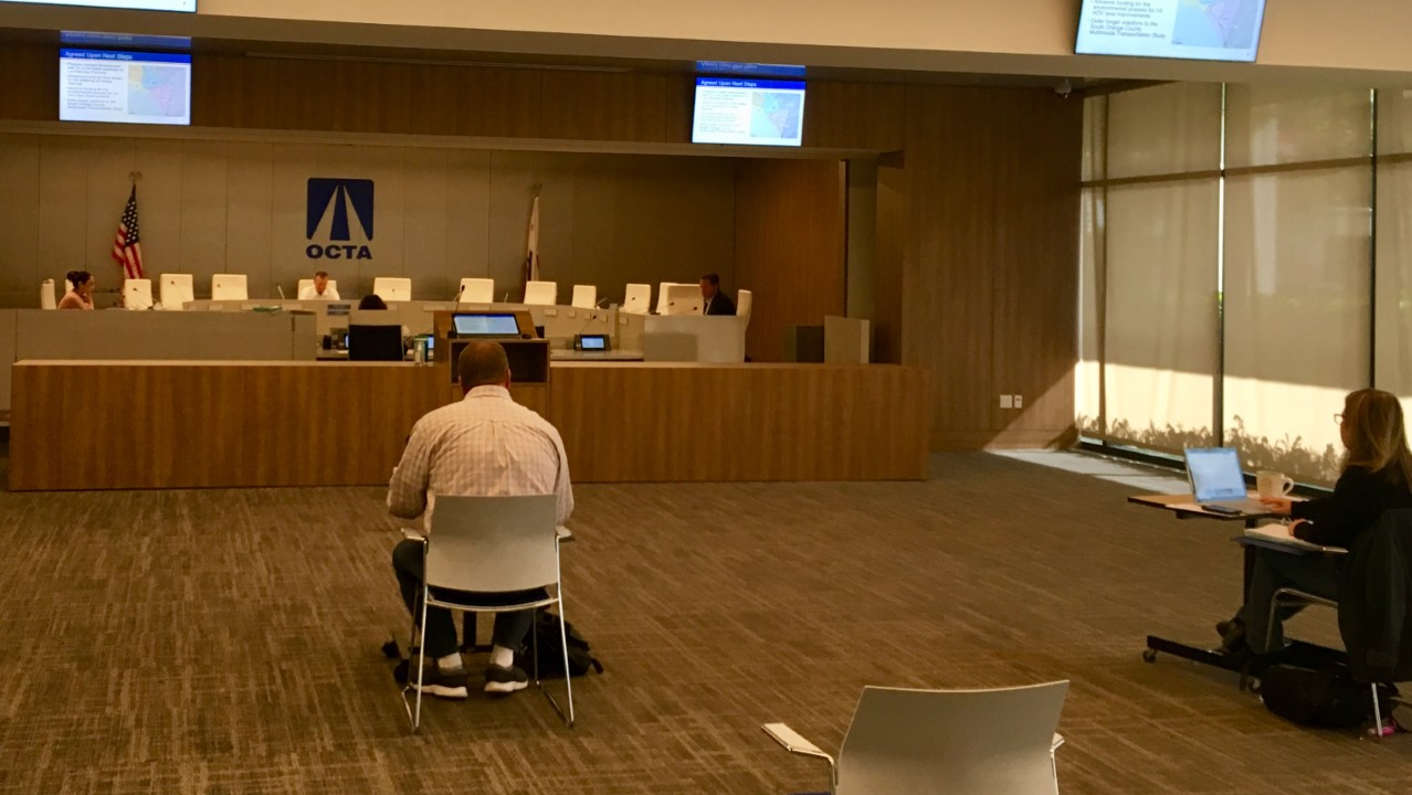 OCTA held its April 13 Board of Directors meeting via teleconference. Only the Board Chairman Steve Jones (center), CEO Darrell E. Johnson (right) and clerk Martha Ochoa (left) are at the dais, with less than 10 people in a room that holds 150.