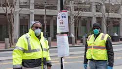 COVID-19 ambassadors at a bus stop on Market Street. COVID-19 ambassadors at a bus stop on Market Street.