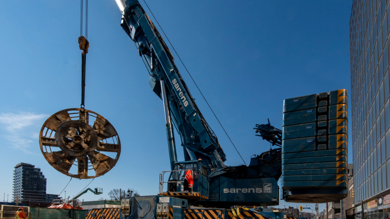 The 6-metre (19.7-foot) long cutter head from one of the tunnel boring machines used on the Eglinton Crosstown subway project is lifted from deep underground.