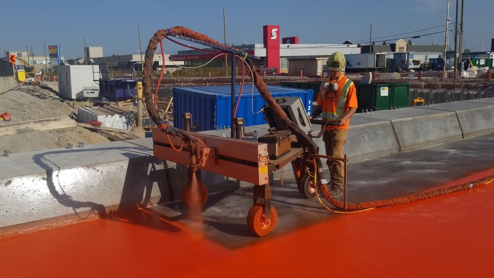Construction crews waterproofing the bridge deck.