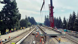 A track panel is moved via crane to its spot within the right of way. A track panel is moved via crane to its spot within the right of way.
