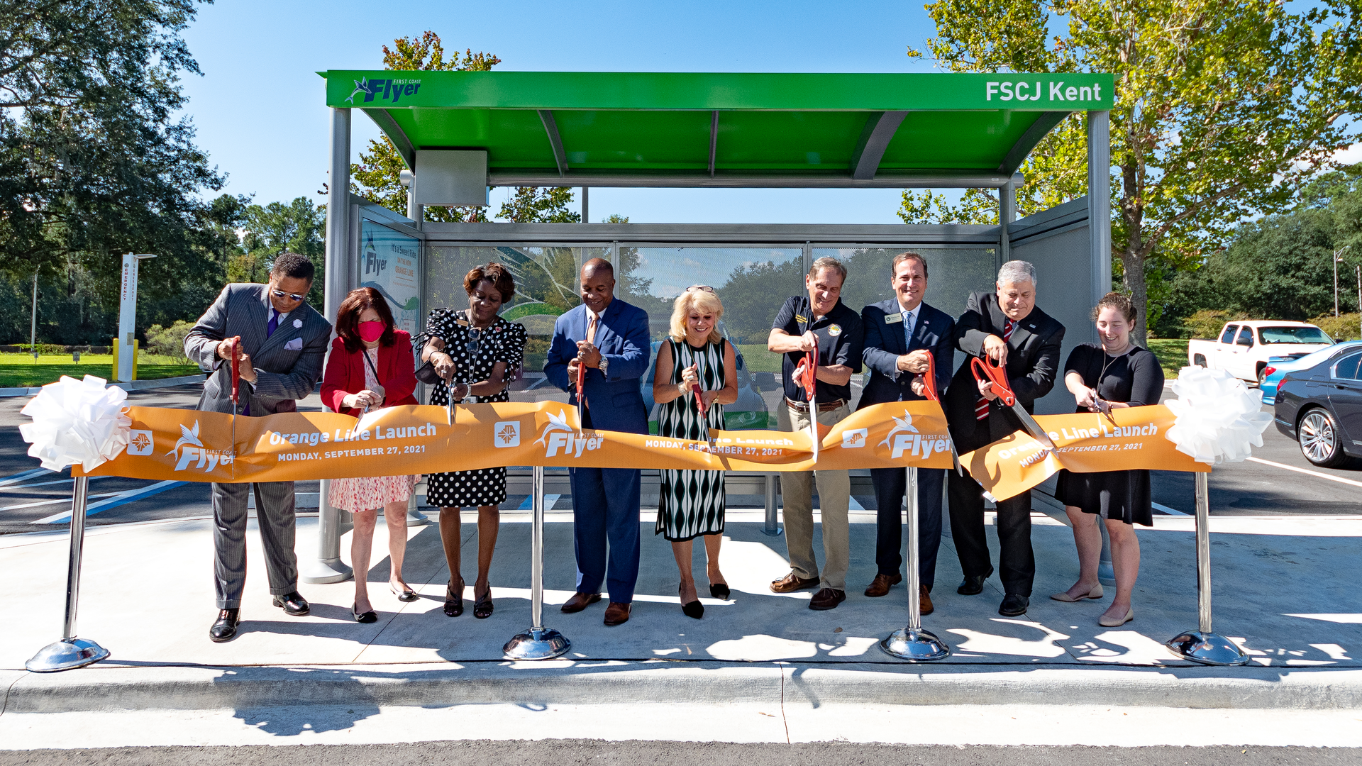 Officials cut the ribbon at a bus stop to mark the opening of JTA's First Coast Flyer Orange Line.