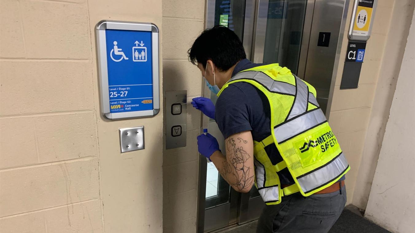 Hygiene Officer Brandon Nguyen tests elevator buttons.