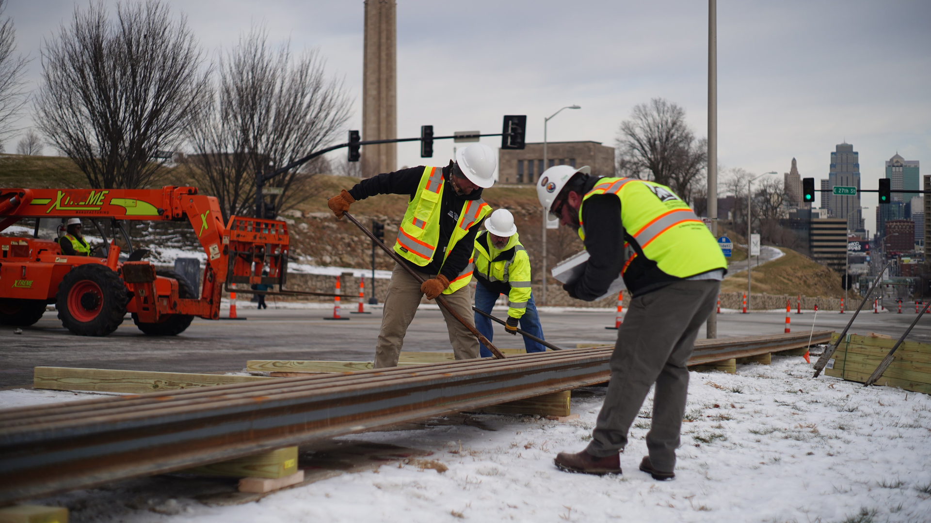 Workers lay the rail in the staging area at 27th & Main St.