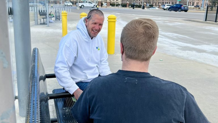 A Chestnut Health employee interacts with a rider on the St. Louis Metro transit system.
