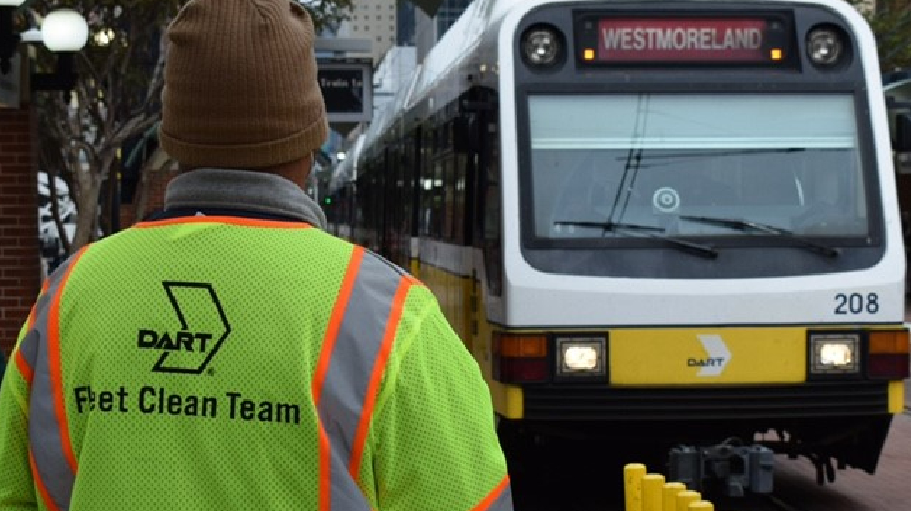 The back of a DART Clean Team uniform employee as they look at a bus