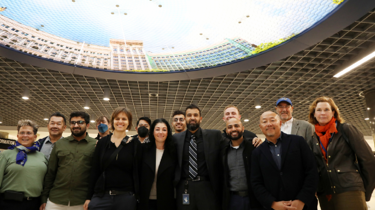 The team behind the Powell St. Modernization Program poses for a photo under &ldquo;Elysium&rdquo; by Stephen Galloway on Nov. 22, 2022.