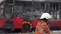 A bus burning from a fire with fire department on site. A bus burning from a fire with fire department on site.
