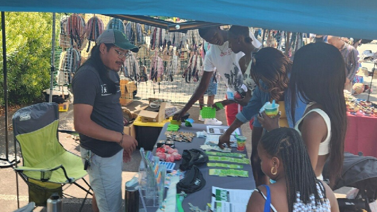 GoTriangle employee shares information on public transit and services at the 18th Annual North Carolina Juneteenth Celebration in Durham.