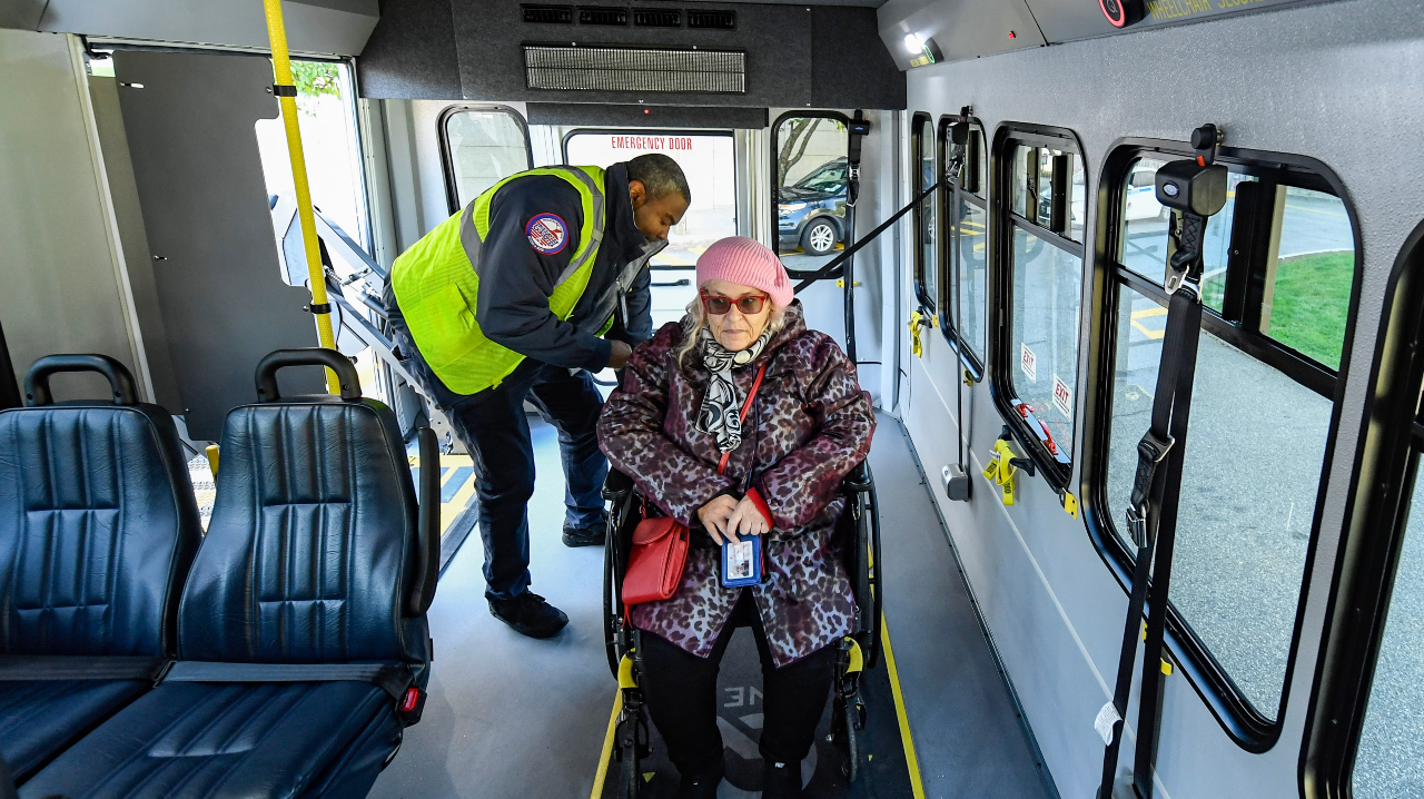 An MTA employee strapping down a wheelchair.