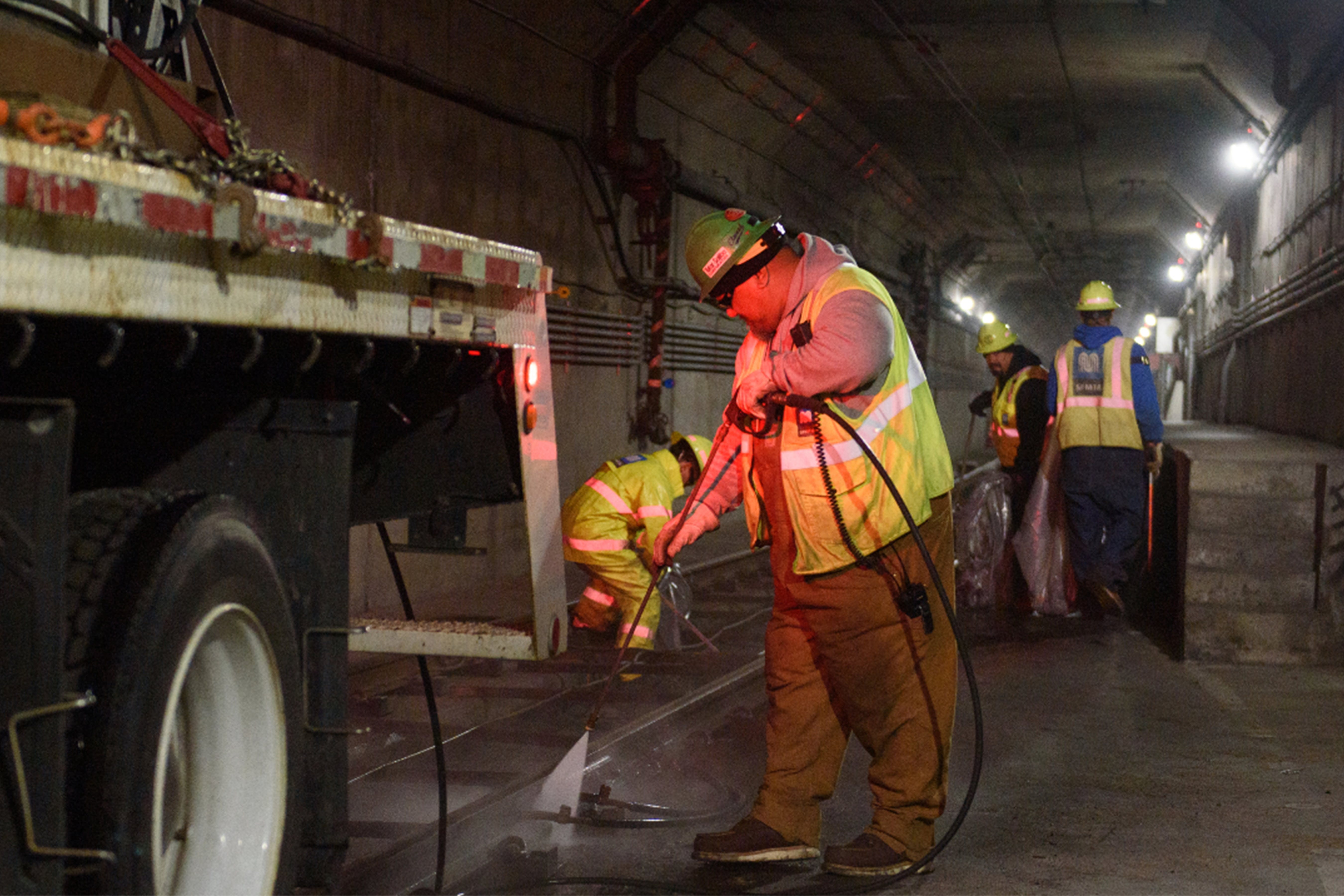 Track crew power washing and removing trash from trackway during Fix It Week night maintenance work.