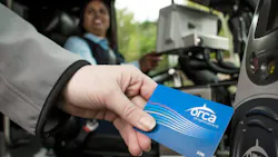 A woman hand-swiping an ORCA LIFT card. A woman hand-swiping an ORCA LIFT card.
