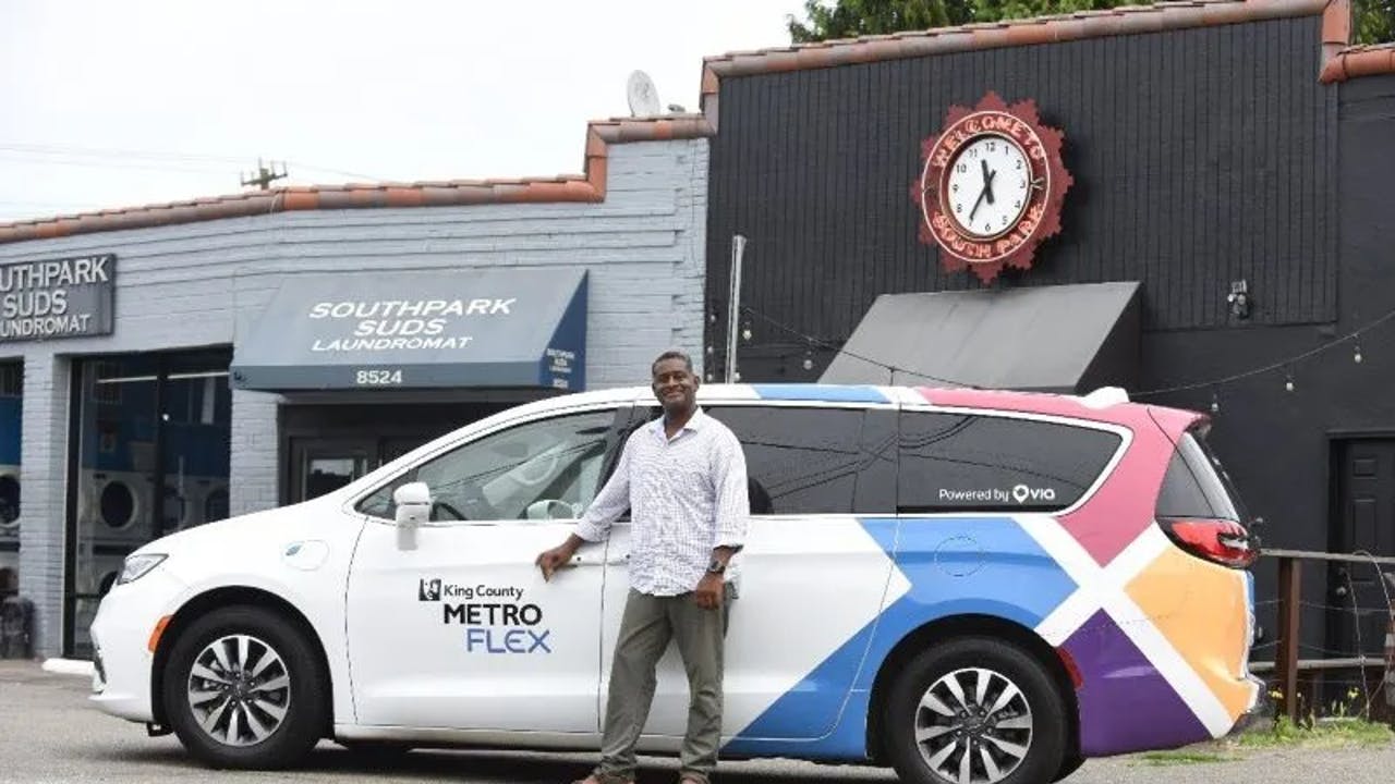 A Metro Flex driver smiles while parked next to South Park Suds Laundromat.