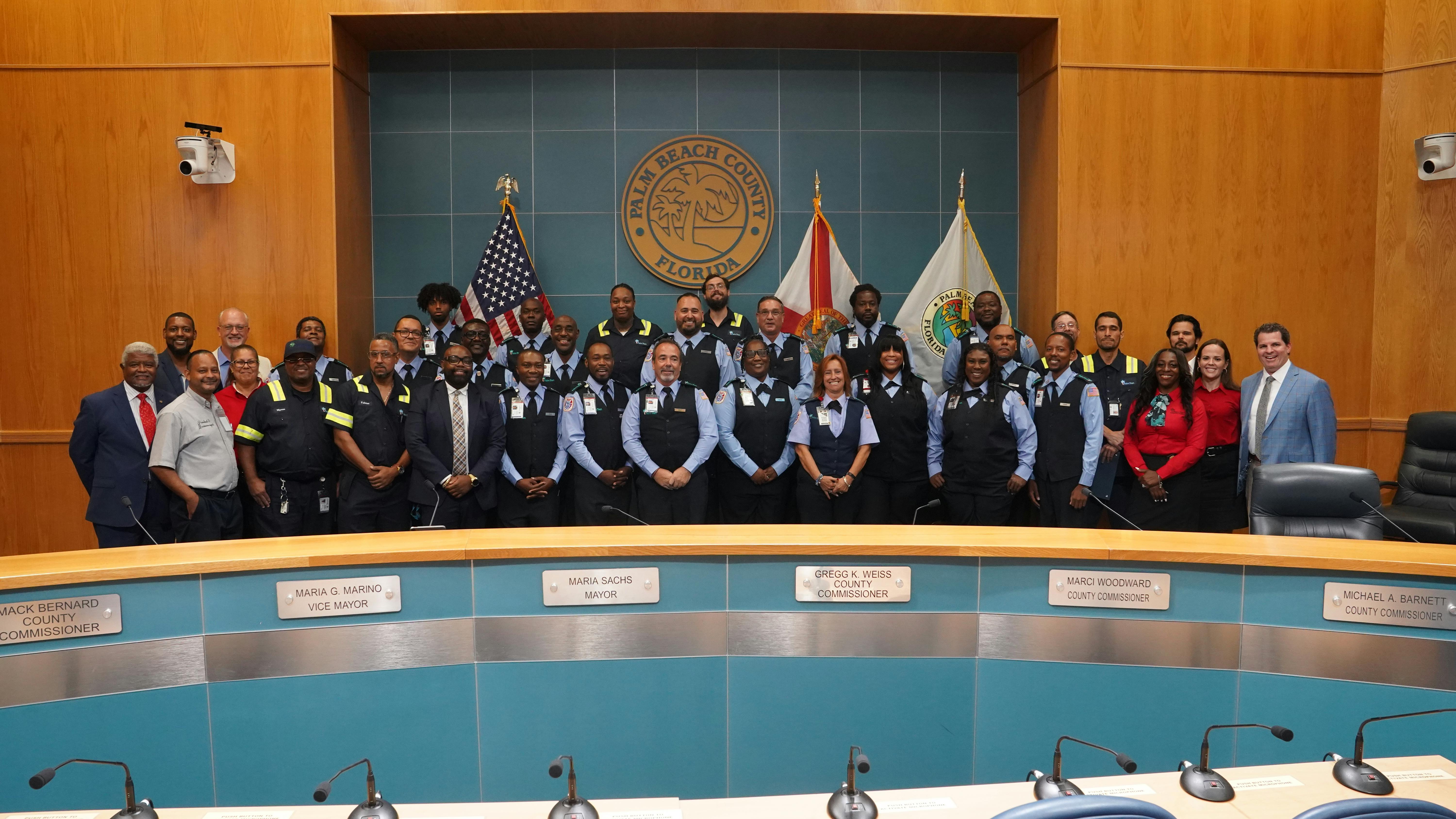Graduates posing with speakers and training staff.