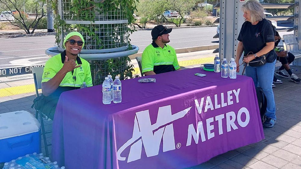 Valley Metro Customer Experience Coordinators hosting a Heat Relief pop-up at a light-rail platform.