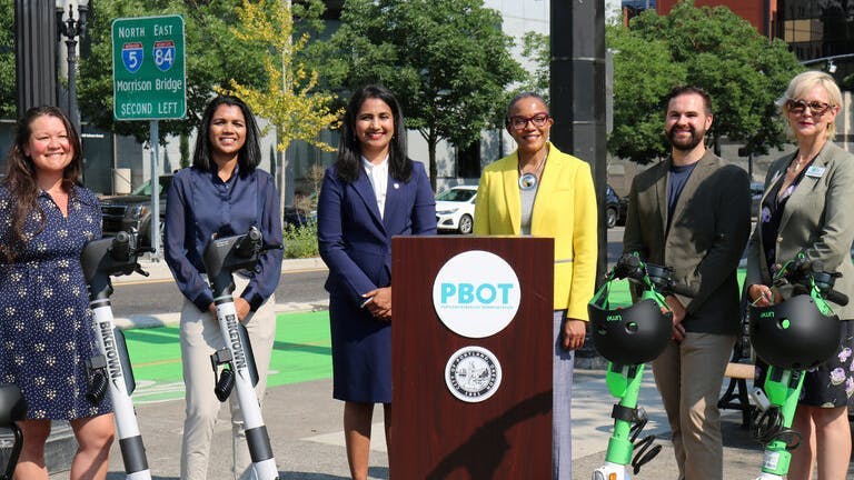 Leaders with the City of Portland, the PBOT, the scooter companies and community organizations spoke at a news conference Aug. 8. From left to right, they are Momoko Saunders, vendor manager for Suma, Kanika Agrawal, regional director of micromobility operations for Lyft, Priya Dhanapal, deputy city administrator for publicworks for the City of Portland, PBOT Director Millicent Williams, Hayden Harvey, director of government relations for Lime and Sarah Lannarone, executive director of The Street Trust.