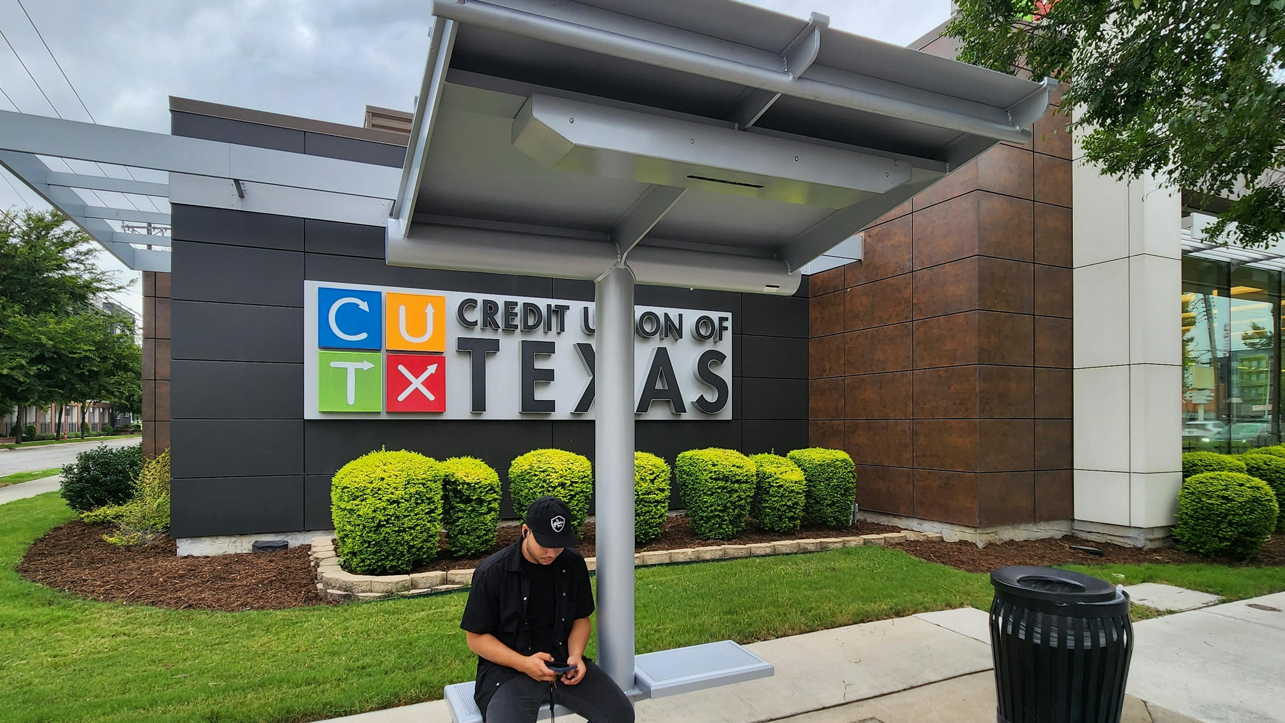 A resident waiting at one of DART's Next Generation Bus Shelters.