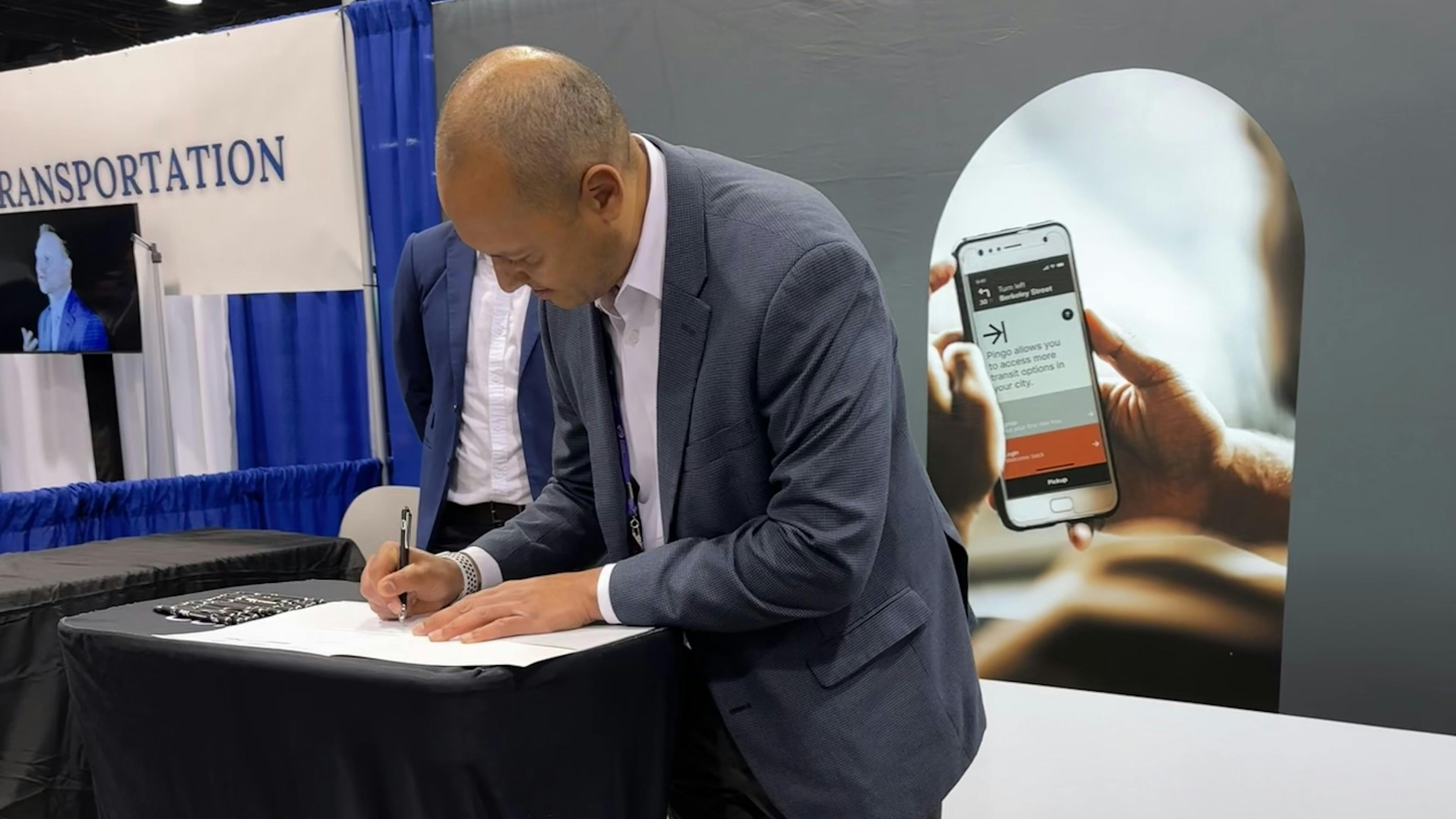 RTS CEO Miguel Vel&aacute;zquez signs the agreement with TRC during APTA's TRANSform conference.