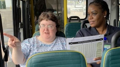 Two people sitting on a bus.