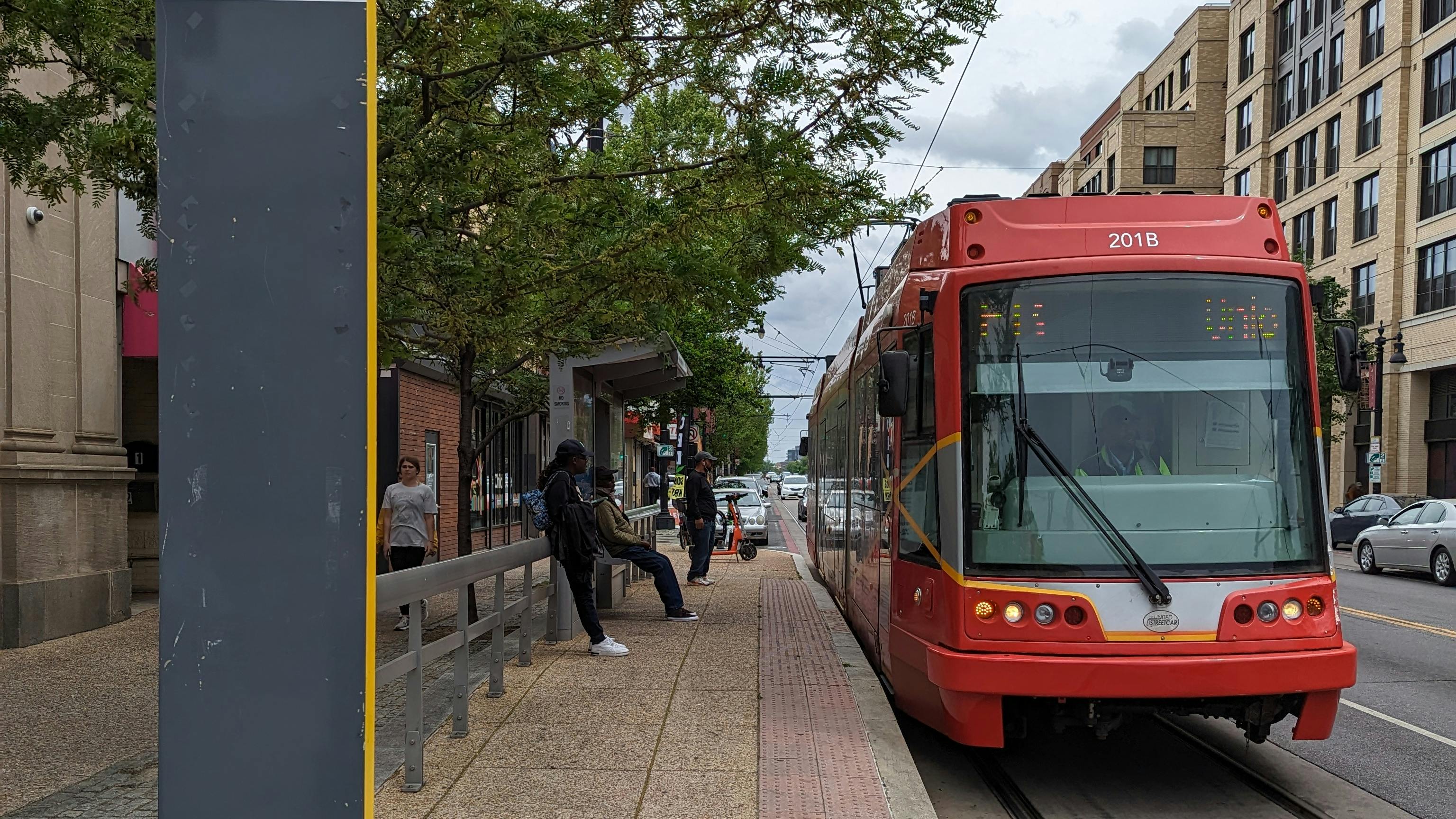 a red light rail vehicle waits at an outdoor station