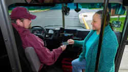 An Arrowhead Transit bus operator talking to a passenger on the steps of a bus. An Arrowhead Transit bus operator talking to a passenger on the steps of a bus.