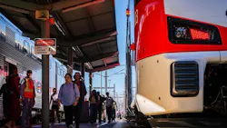 people pass an electric train at a caltrain station people pass an electric train at a caltrain station