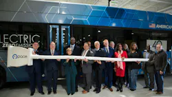 officials stand with giant plug in in front of Pace electric bus officials stand with giant plug in in front of Pace electric bus