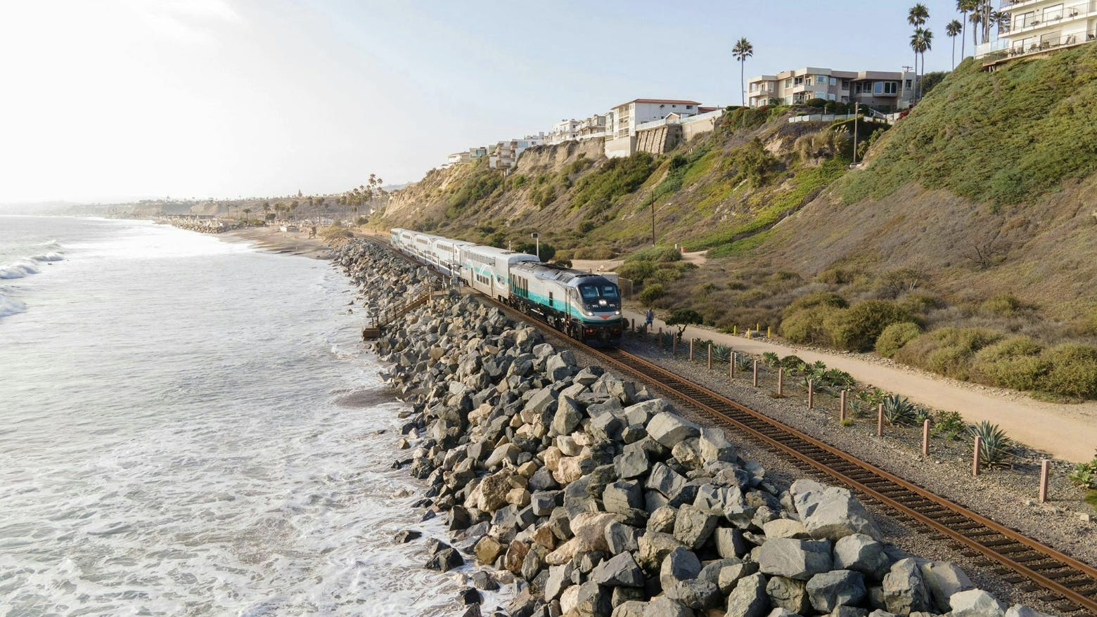 Metrolink train runs on track next to bluffs and the ocean
