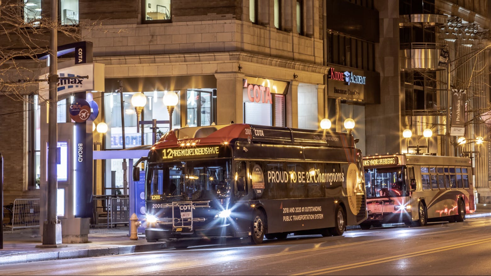 COTA bus drives down street in town center at night