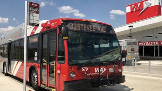 VIA branded bus pulls up to bus stop outside VIA transit center