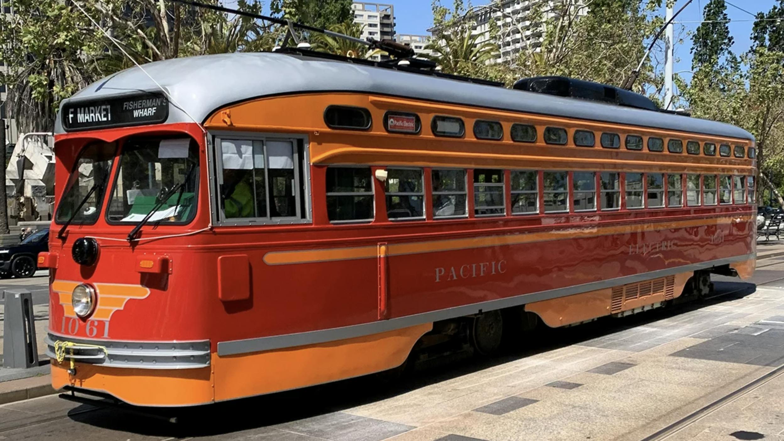 An SFMTA heritage trolley operates down the track
