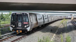 a WMATA orange line train operates down a track under an overpass a WMATA orange line train operates down a track under an overpass