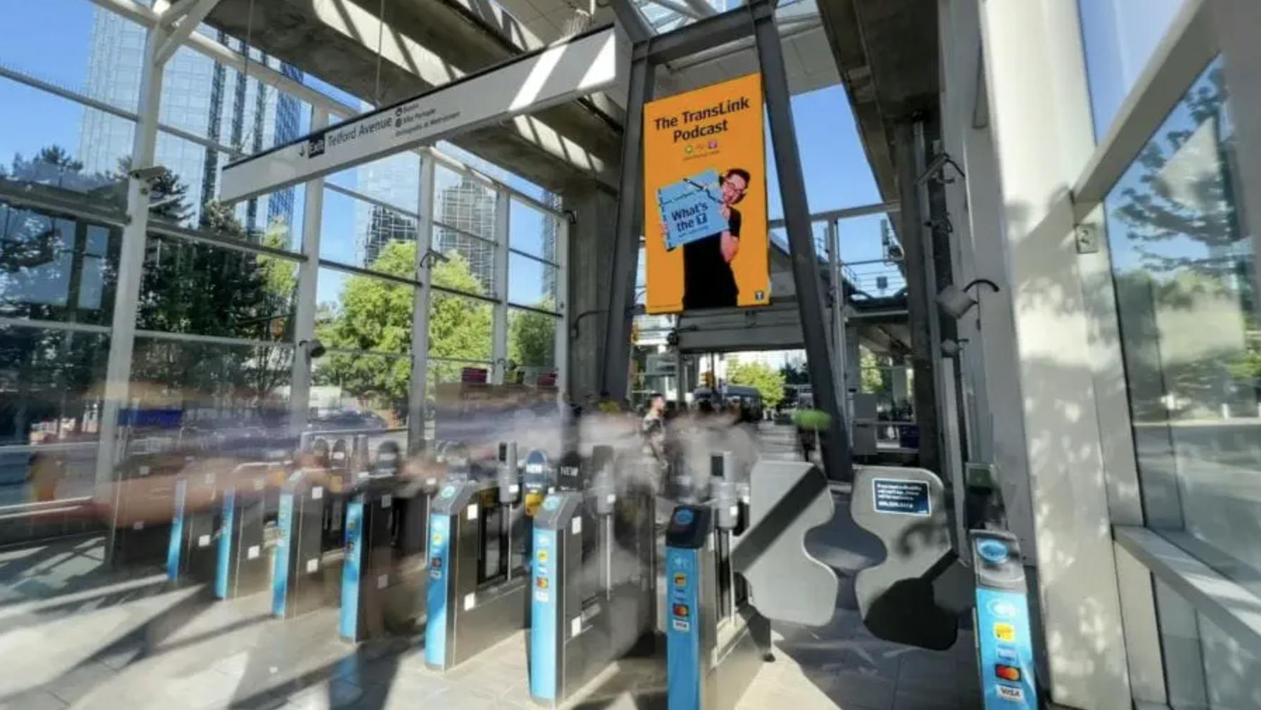 picture of a station entrance that shows the fare gates and a tall signage display