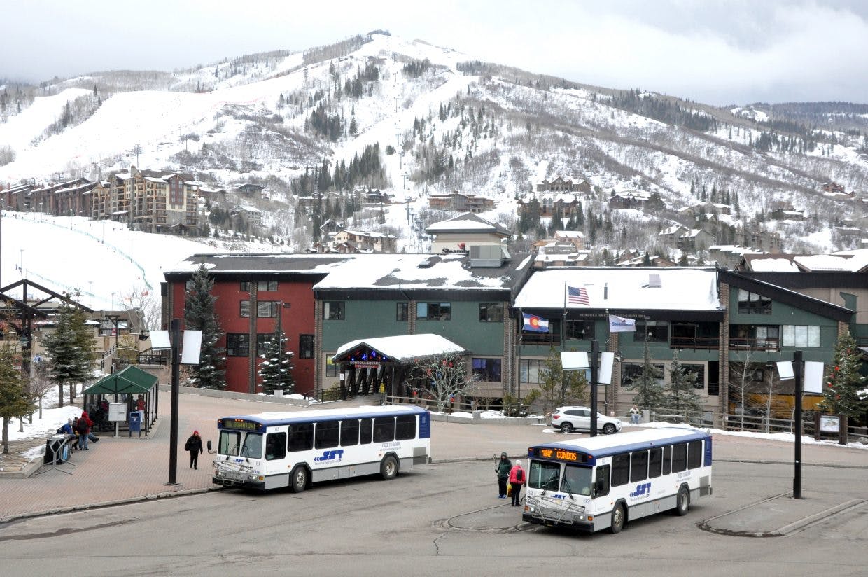 Buses sit parked at a ski complex.