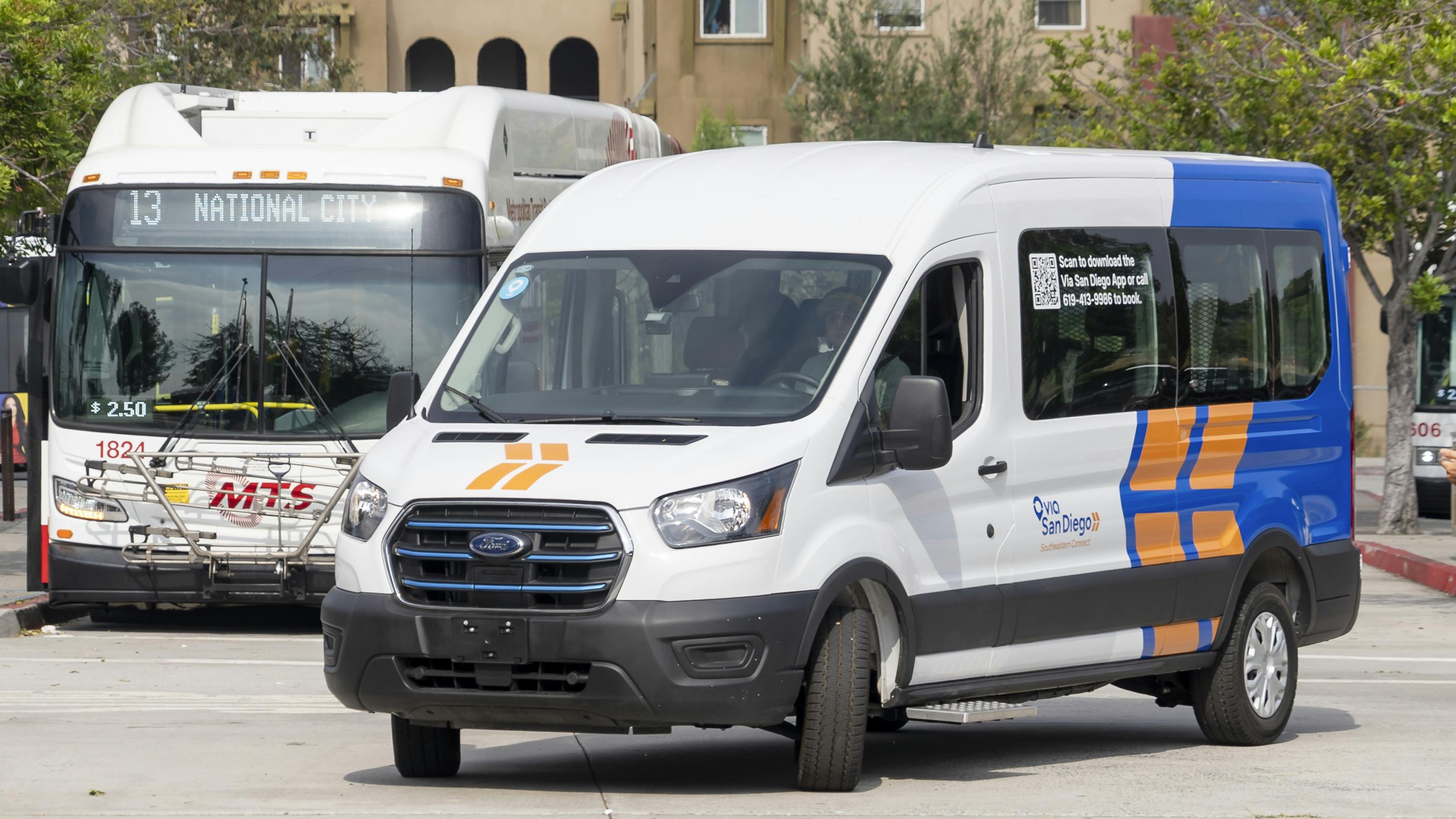 A Southeastern Connect e-transit van sits parked in front of an MTS bus.