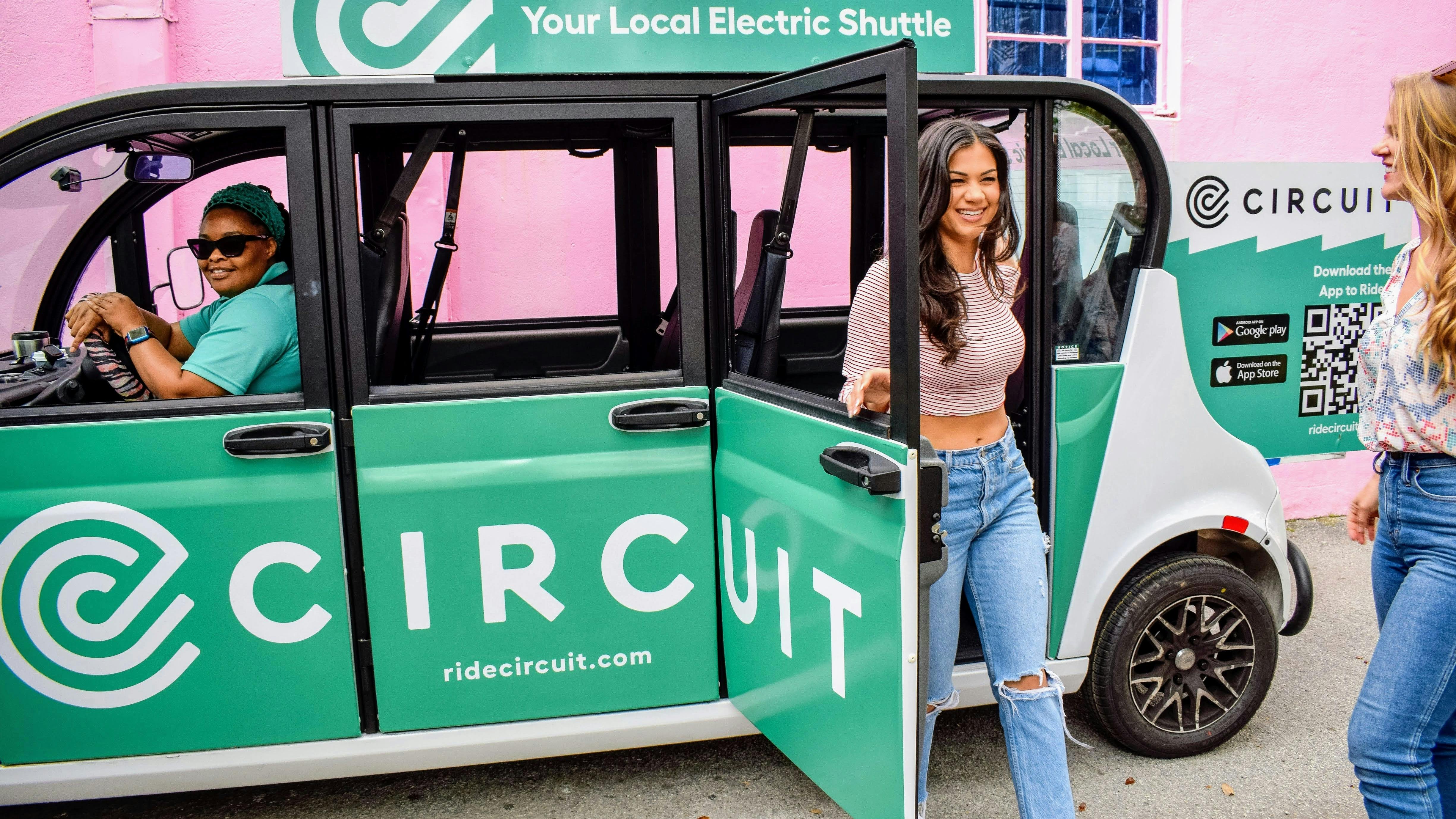 A woman exits a Circuit electric shuttle.